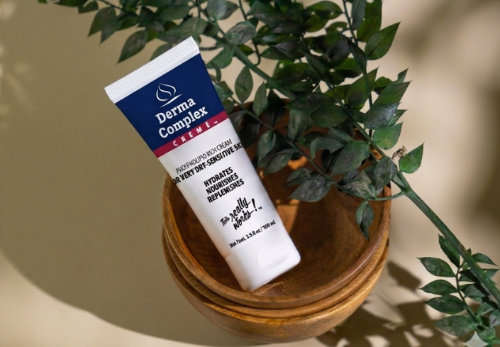 Tube of Derma Complex product on a wooden surface with a plant in the background